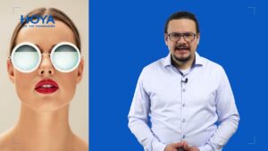 Kobieta w okularach przeciwsłonecznych z lustrzanymi soczewkami, mężczyzna w białej koszuli obok na tle niebieskiego ekranu.