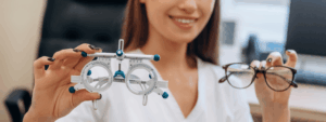 Optometrystka trzyma oprawki próbne i okulary, kontekst krotkowzroczności u dzieci