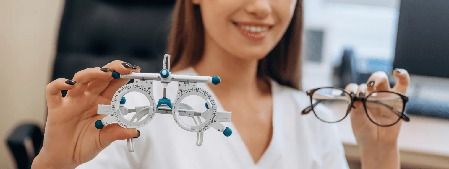 Optometrystka trzyma oprawki próbne i okulary, kontekst krotkowzroczności u dzieci